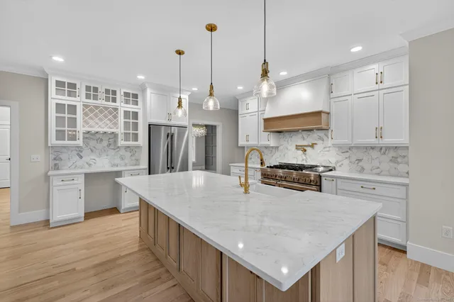 a large kitchen with stainless steel appliances kitchen island granite countertop a stove and a sink