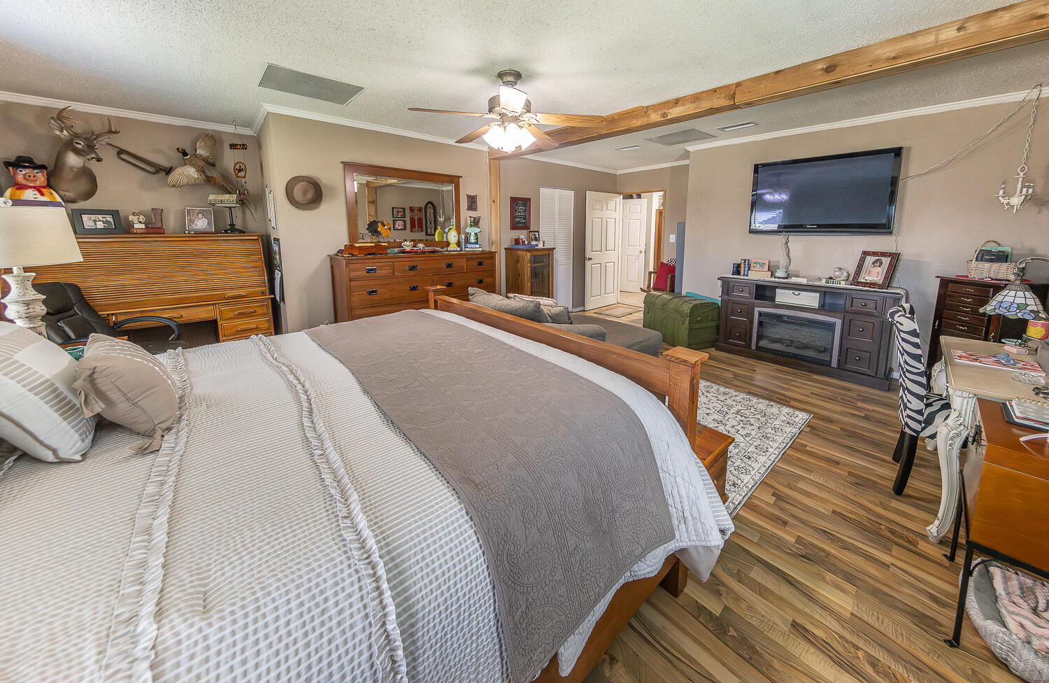 450 South 12th Street Slaton, TX 79364 - Photo 12 of 26 a spacious bedroom with a bed a couch and dresser