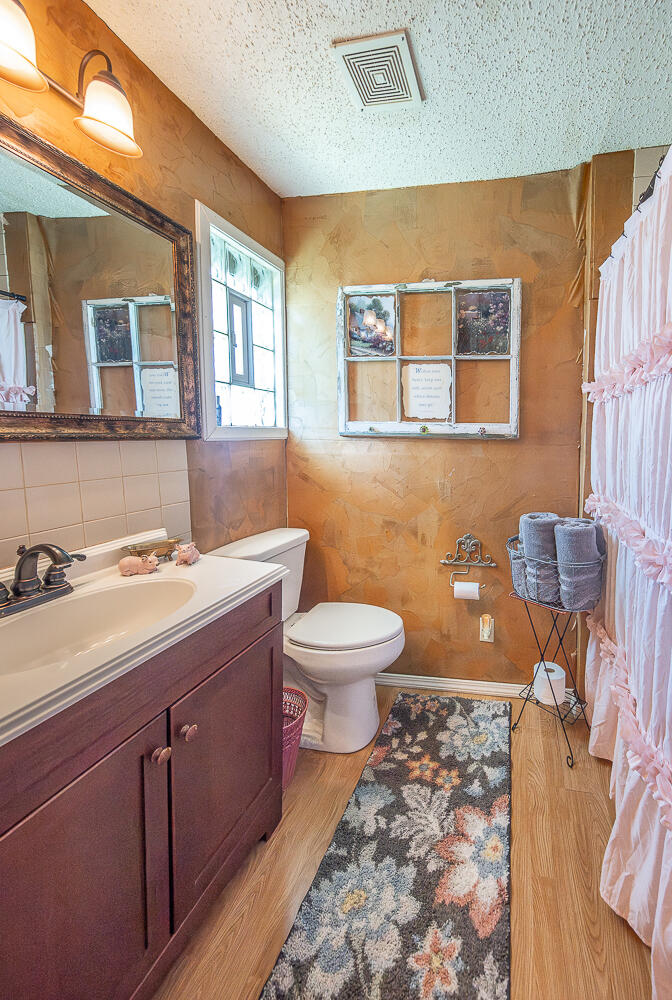 450 South 12th Street Slaton, TX 79364 - Photo 15 of 26 a bathroom with a sink a toilet and mirror