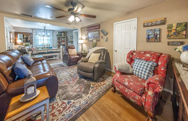 a living room with furniture ceiling fan and a rug