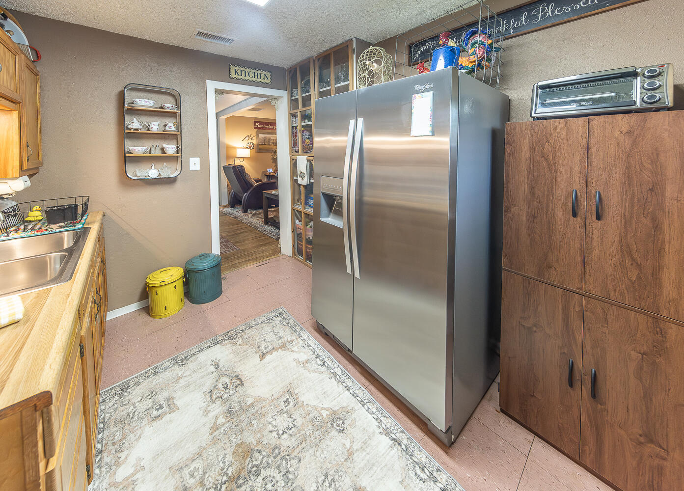 450 South 12th Street Slaton, TX 79364 - Photo 8 of 26 a kitchen with a refrigerator and wooden floor