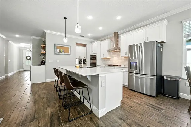 a kitchen with stainless steel appliances granite countertop a refrigerator and a stove top oven