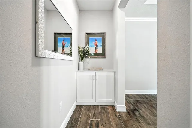 a view of a hallway with wooden floor and staircase