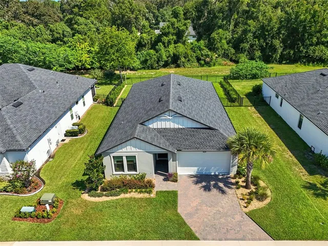 a kitchen with stainless steel appliances granite countertop a stove a sink a microwave a dining table and chairs with wooden floor