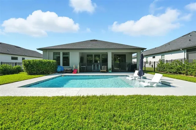 a kitchen with stainless steel appliances kitchen island granite countertop a refrigerator a stove a sink a dining table and chairs with wooden floor