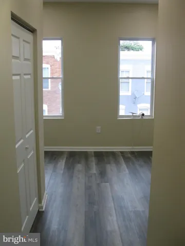 a view of a small space with wooden floor and a window