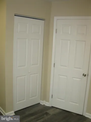 an empty room with wooden floor and closet area