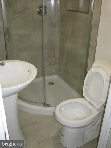 a white toilet sitting next to a bath tub and a shower