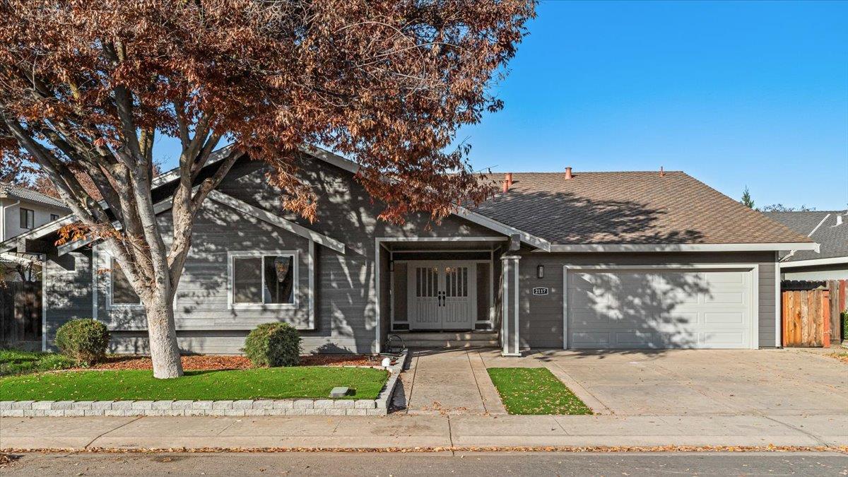 2117 Manitoba Court Modesto, CA 95356 - Photo 1 of 1 a front view of a house with a garden and trees