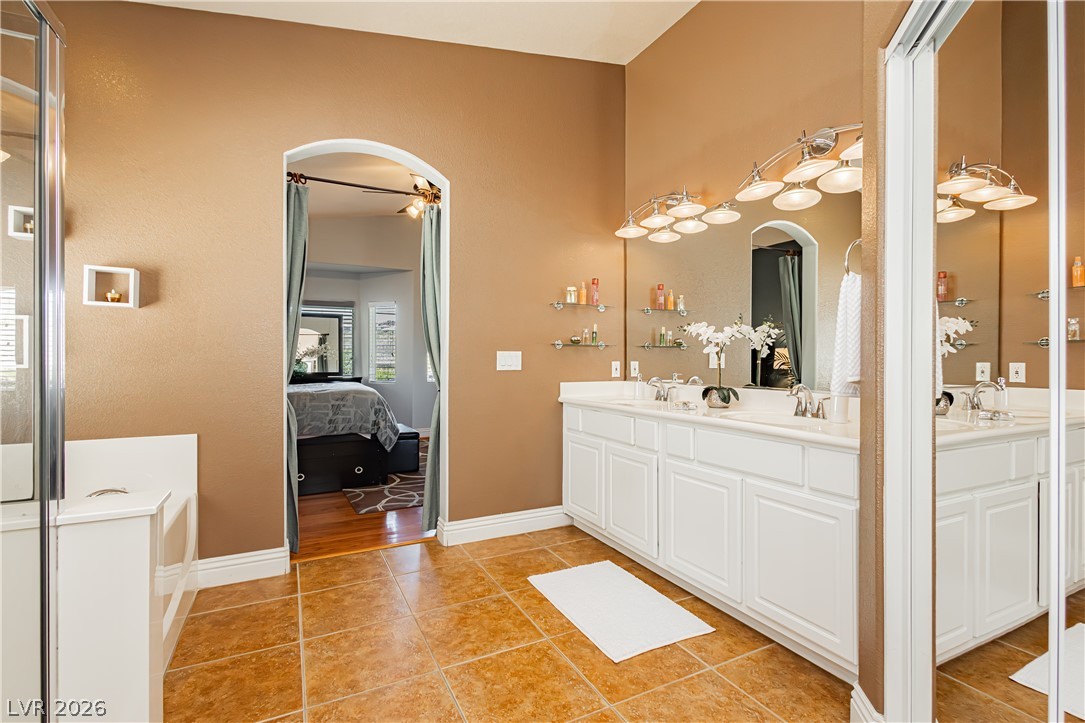 2256 Dogwood Ranch Avenue Henderson, NV 89052 - Photo 40 of 51 Double vanity and tiled flooring distinguish this well-appointed primary bathroom, with seamless access to the primary bedroom.