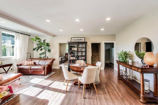 a living room with furniture a bookshelf and a wooden floor