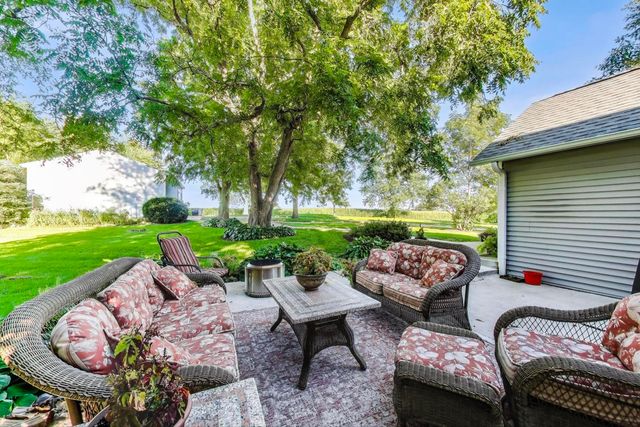 a view of a patio with couches potted plants and a big yard