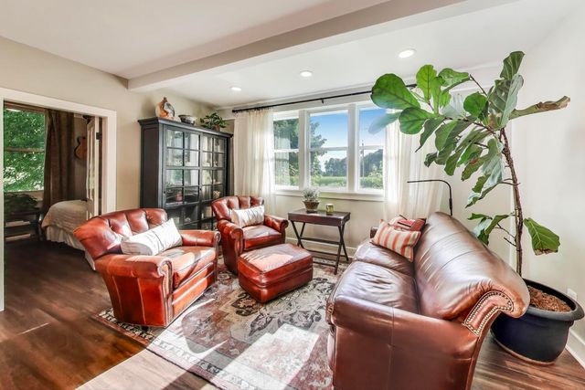 a living room with furniture a large window and a potted plant