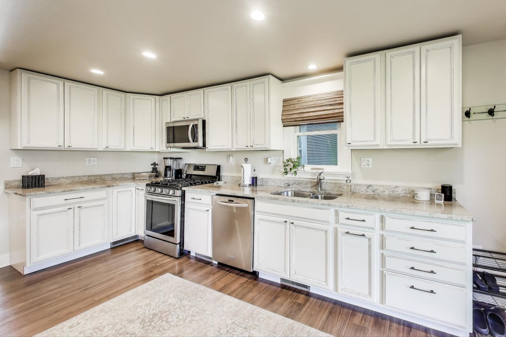 4608 Alden Road Woodstock, IL 60098 - Photo 10 of 42 a kitchen with granite countertop white cabinets and white appliances