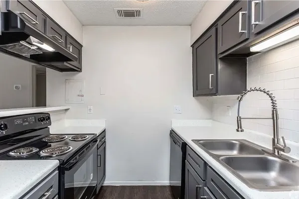 a kitchen with a sink stove and cabinets