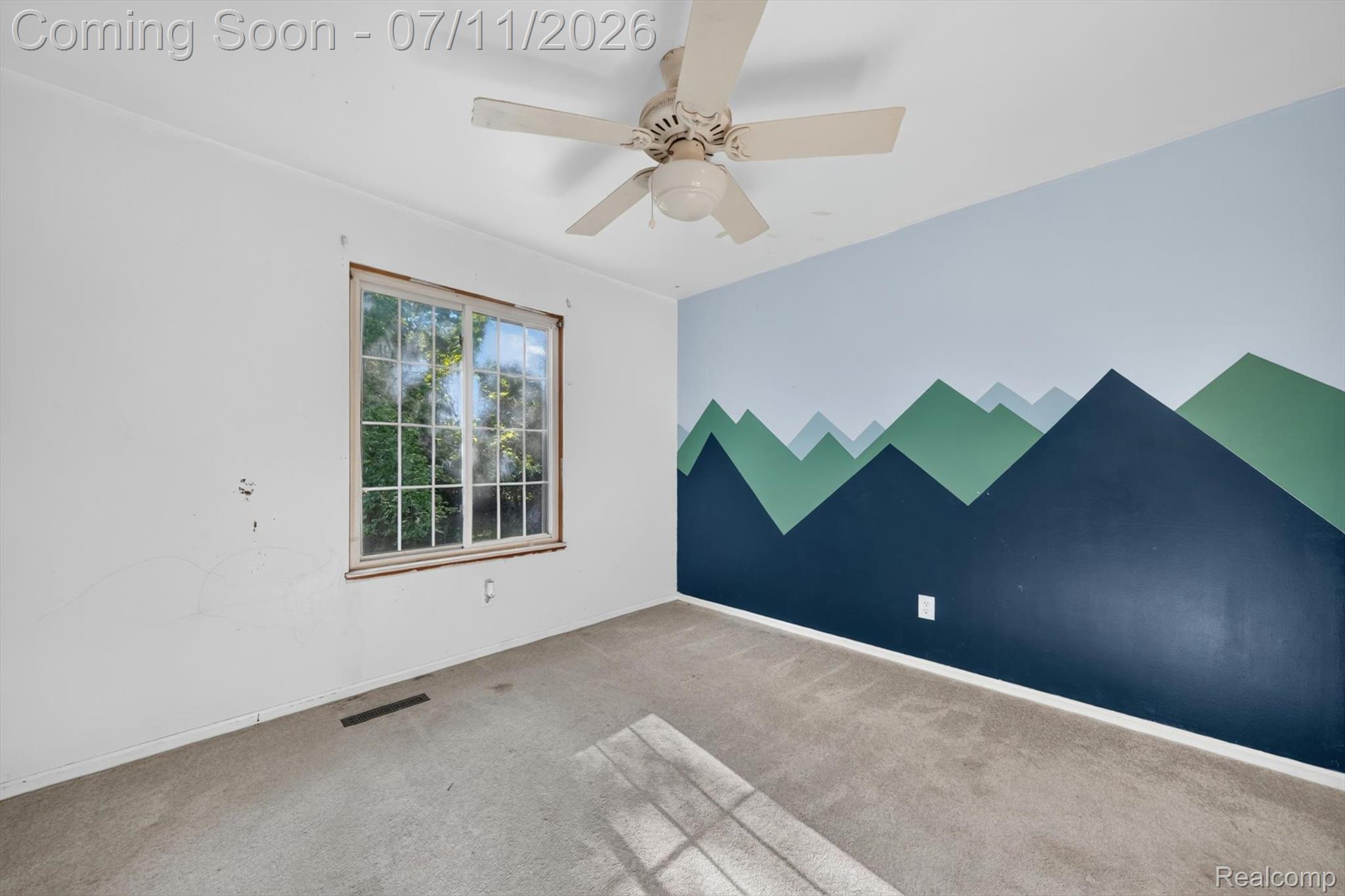 4430 North Center Road Flint, MI 48506 - Photo 20 of 49 Interior room featuring a painted accent wall with a mountain motif, a large window, a ceiling fan, and carpet flooring