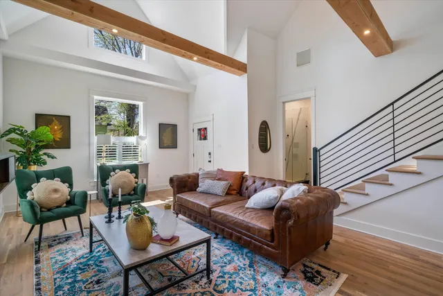 a living room with furniture kitchen view and a wooden floor