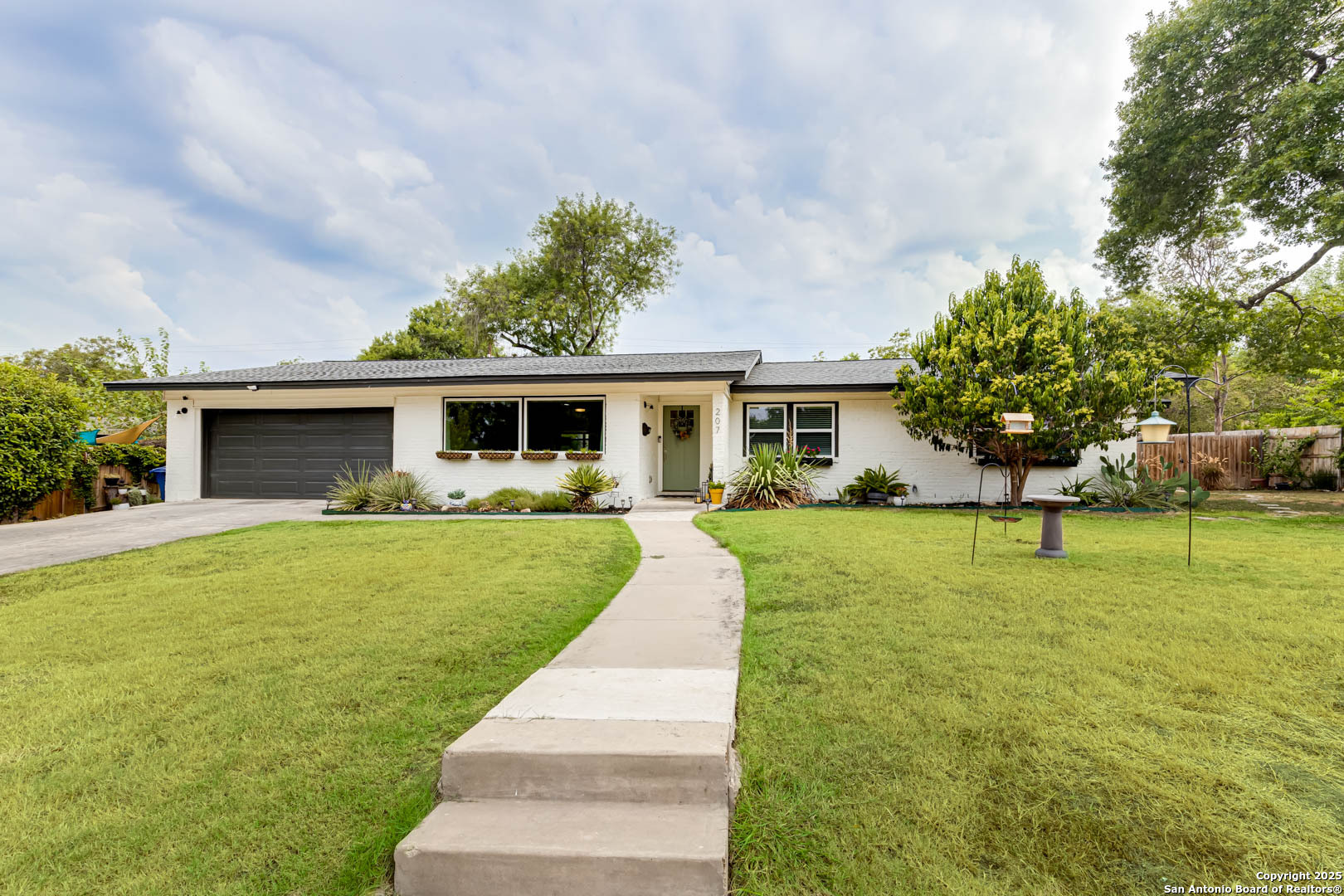 207 Meadowood Lane San Antonio, TX 78216 - Photo 1 of 1 a front view of house with a garden and trees