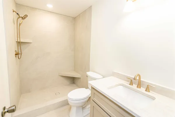 a bathroom with a sink a toilet and shower