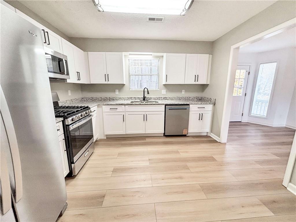 5907 Brookside Drive Southeast Mableton, GA 30126 - Photo 11 of 35 a large kitchen with granite countertop a stove top oven a sink dishwasher and a refrigerator