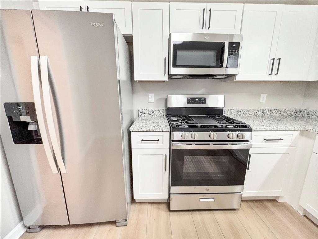 5907 Brookside Drive Southeast Mableton, GA 30126 - Photo 12 of 35 a kitchen with stainless steel appliances a white stove a microwave and a refrigerator