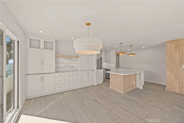 a kitchen with a white cabinets and wooden floor