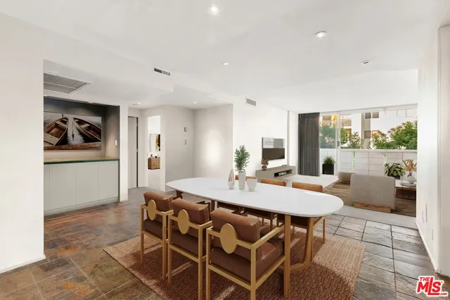 a view of a dining room and livingroom with furniture wooden floor and a rug