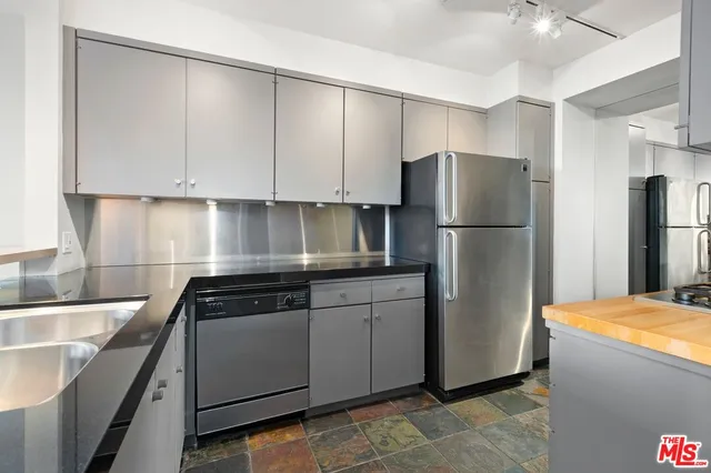 a kitchen with a refrigerator sink and cabinets