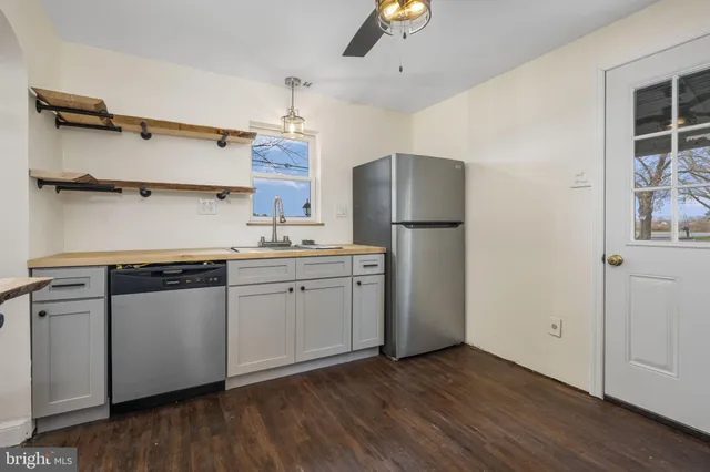 a kitchen with a refrigerator and a stove top oven