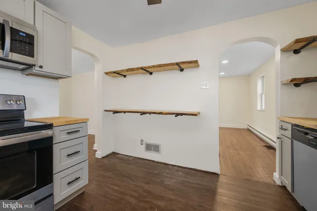 a kitchen with cabinets and wooden floor