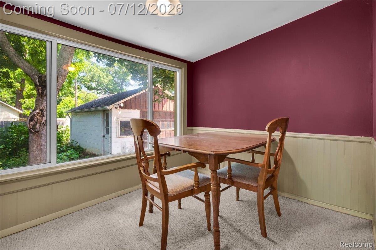 624 North Prospect Road Ypsilanti, MI 48198 - Photo 17 of 28 Spacious room featuring a wide picture window, an overhead light fixture, white ceiling, and paneled wainscoting