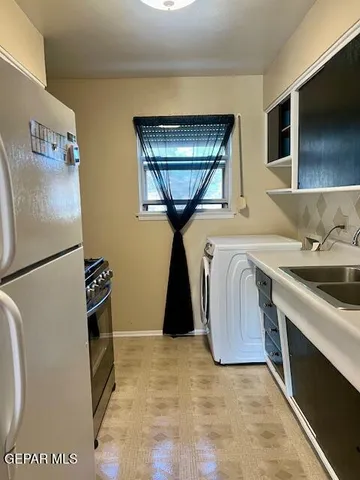 a kitchen with a refrigerator sink and cabinets