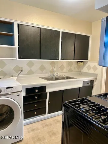 a view of kitchen with a stove and a sink