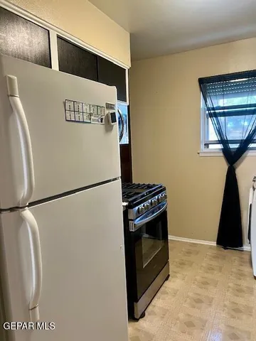 a white refrigerator freezer and a stove sitting inside of a kitchen