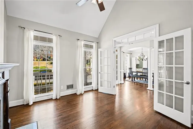 a view of an empty room with wooden floor fireplace and a window