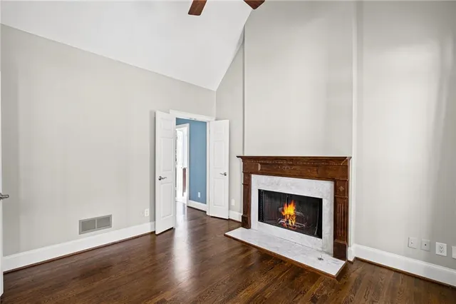 a view of a livingroom with wooden floor and a fireplace