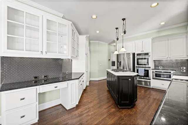 a kitchen with granite countertop white cabinets and sink