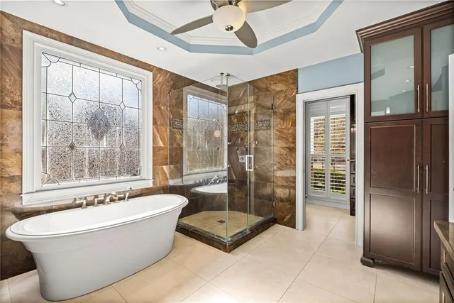 an empty room with windows and chandelier fan