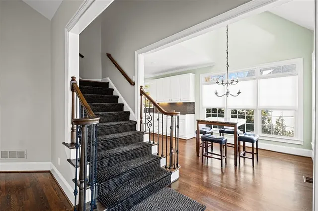 wooden floor in an empty room with a window and a flat screen tv
