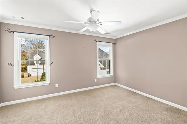 an empty room with windows and fan