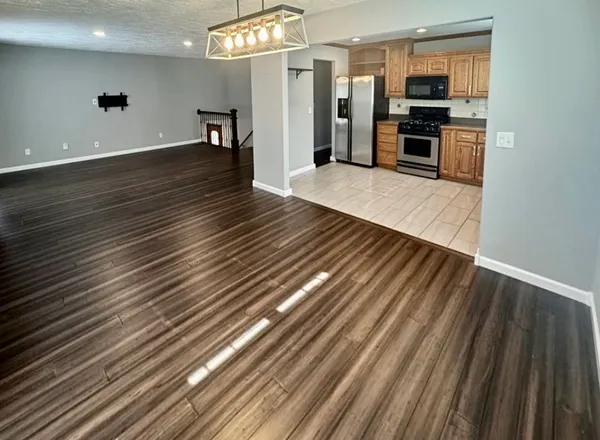 a kitchen with stainless steel appliances a refrigerator and wooden floor