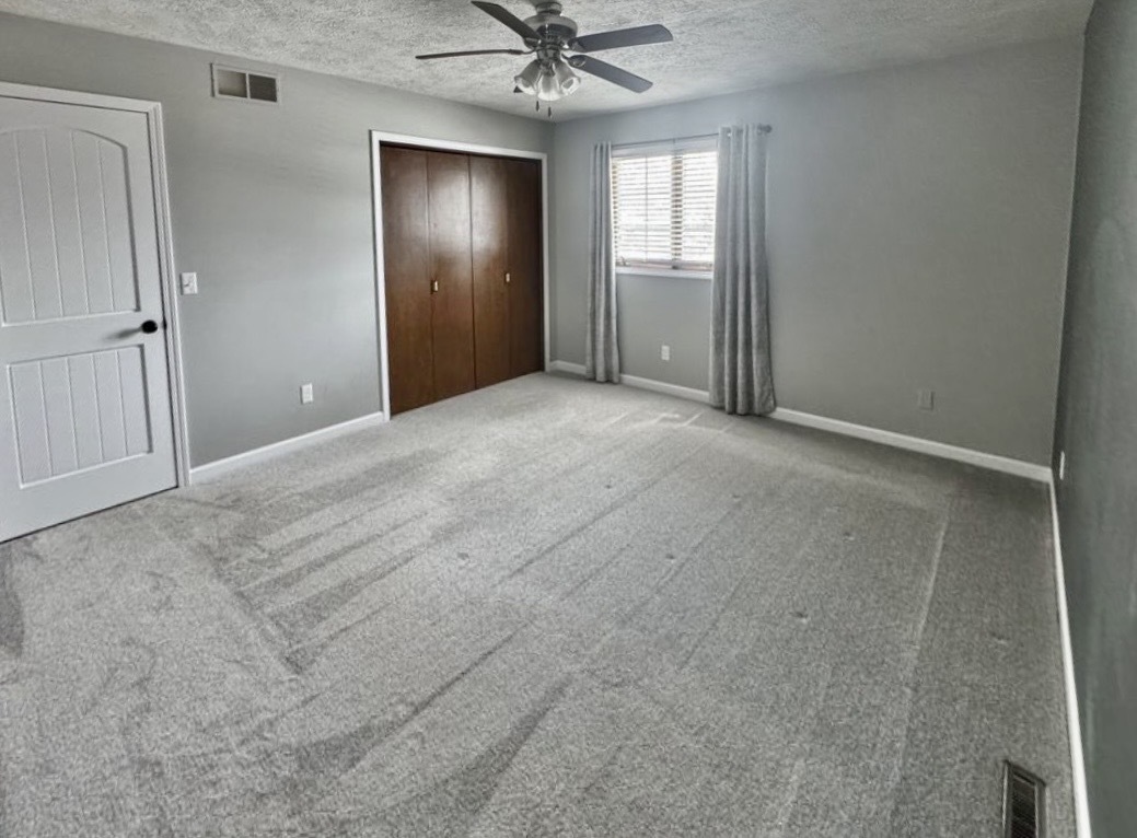117 Colchester Drive Normal, IL 61761 - Photo 21 of 32 an empty room with a ceiling fan and windows