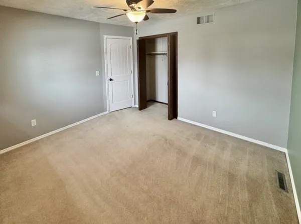a view of an empty room with a chandelier fan
