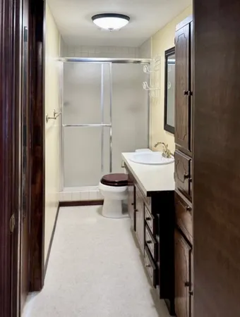 a bathroom with a sink a toilet and shower