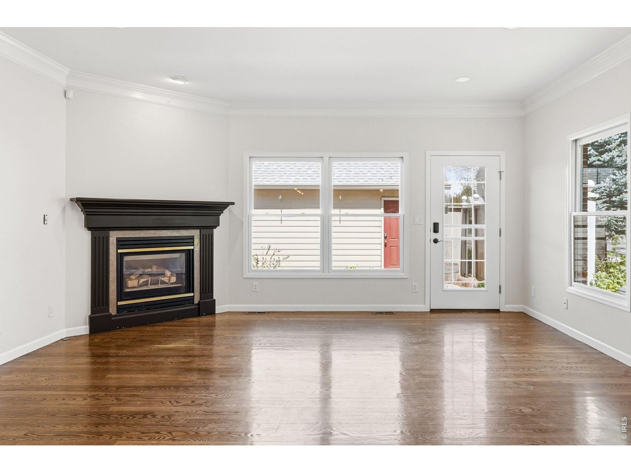 944 Ivanhoe Street Denver, CO 80220 - Photo 12 of 47 a view of an empty room with a window and wooden floor
