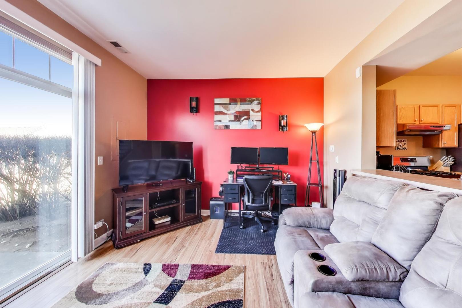 2005 Limestone Lane Carpentersville, IL 60110 - Photo 3 of 23 a living room with furniture a flat screen tv and a fireplace