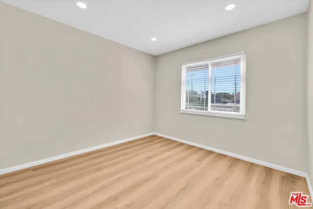 an empty room with a wooden floor and windows
