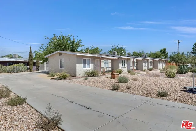 a front view of house with yard and trees in the background