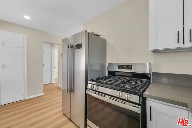 a kitchen with stainless steel appliances granite countertop a refrigerator and a stove top oven