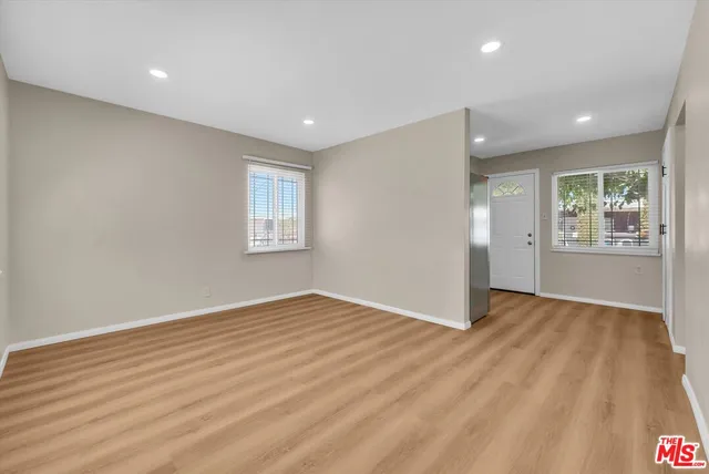 an empty room with windows and closet